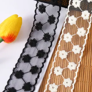 Black and white daisy chains mesh trim — Photographed decorative trim sample; verify colour and construction with a physical sample