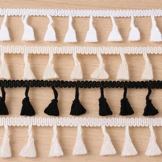 Black and white small tassels fringe trim — Photographed decorative trim sample; verify colour and construction with a physical sample