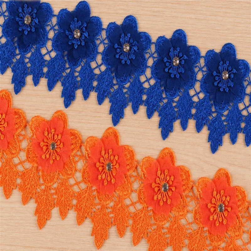 Borde de encaje con flores superpuestas azules y naranjas — Muestra fotografiada de ribete decorativo; compruebe color y construcción con una muestra física