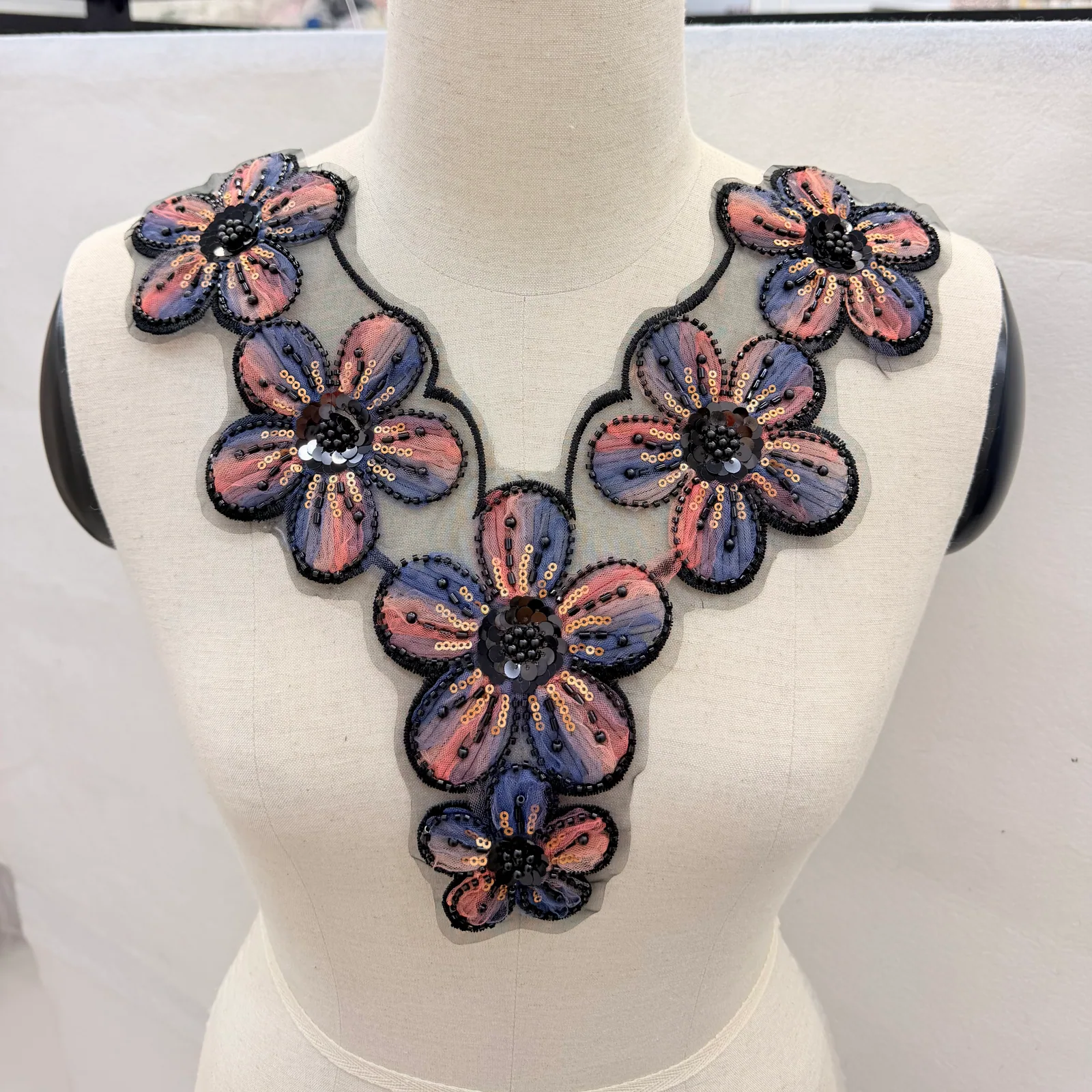Colourful Floral Neckline Panel — Neckline panel placed on a dress form; not a finished garment