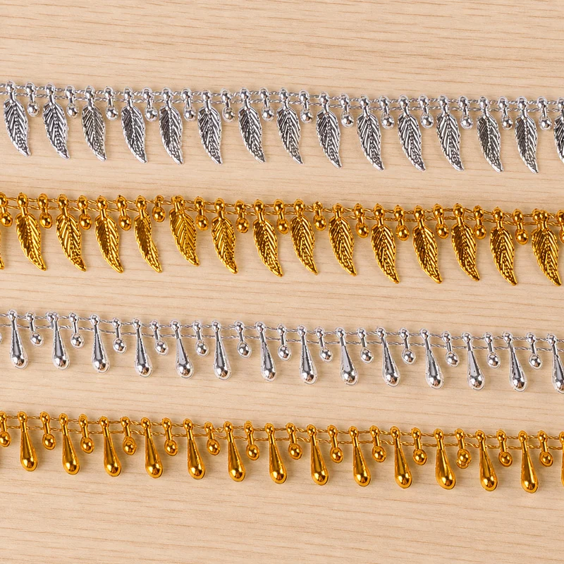 Gold and Silver Teardrop Charm Fringe Trim — Photographed decorative trim sample; verify colour and construction with a physical sample
