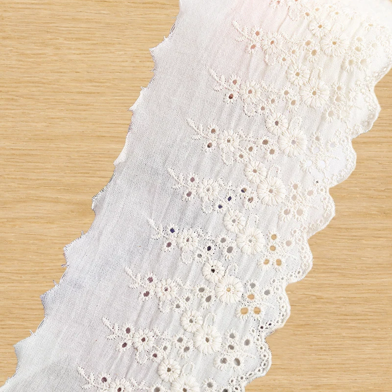 Ivory eyelet daisies openwork trim — Photographed decorative trim sample; verify colour and construction with a physical sample