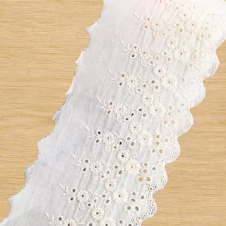 Ivory eyelet daisies openwork trim — Photographed decorative trim sample; verify colour and construction with a physical sample