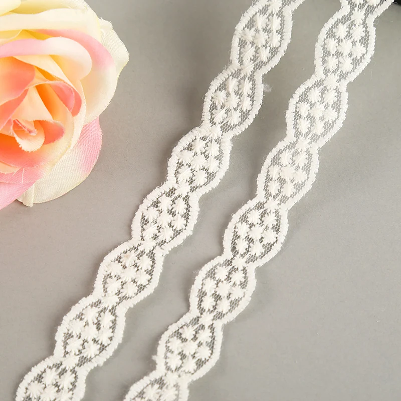 Ivory linked ovals lace trim — Photographed decorative trim sample; verify colour and construction with a physical sample