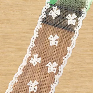 Ivory ribbon bows mesh trim — Photographed decorative trim sample; verify colour and construction with a physical sample