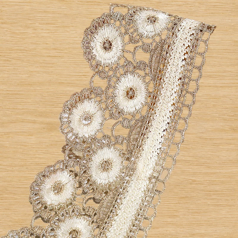 Ivory wheel flower lace trim — Photographed decorative trim sample; verify colour and construction with a physical sample