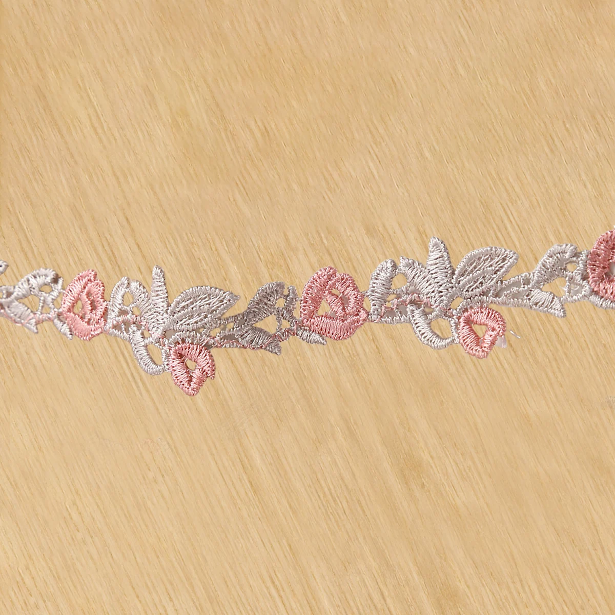 Soft pastel rose lace trim — Photographed decorative trim sample; verify colour and construction with a physical sample