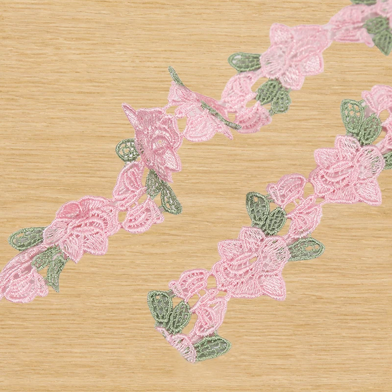 Galon de dentelle à motifs lianes fleuries, tons rose — Échantillon photographié de galon décoratif ; vérifier couleur et construction sur un échantillon réel