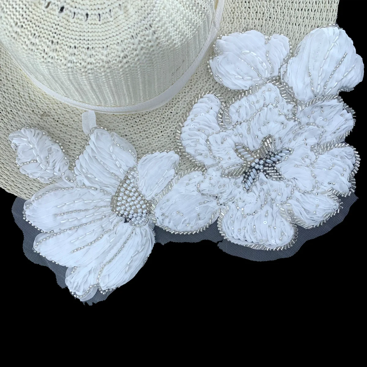Raised white floral appliqué with beads and layered petal details
